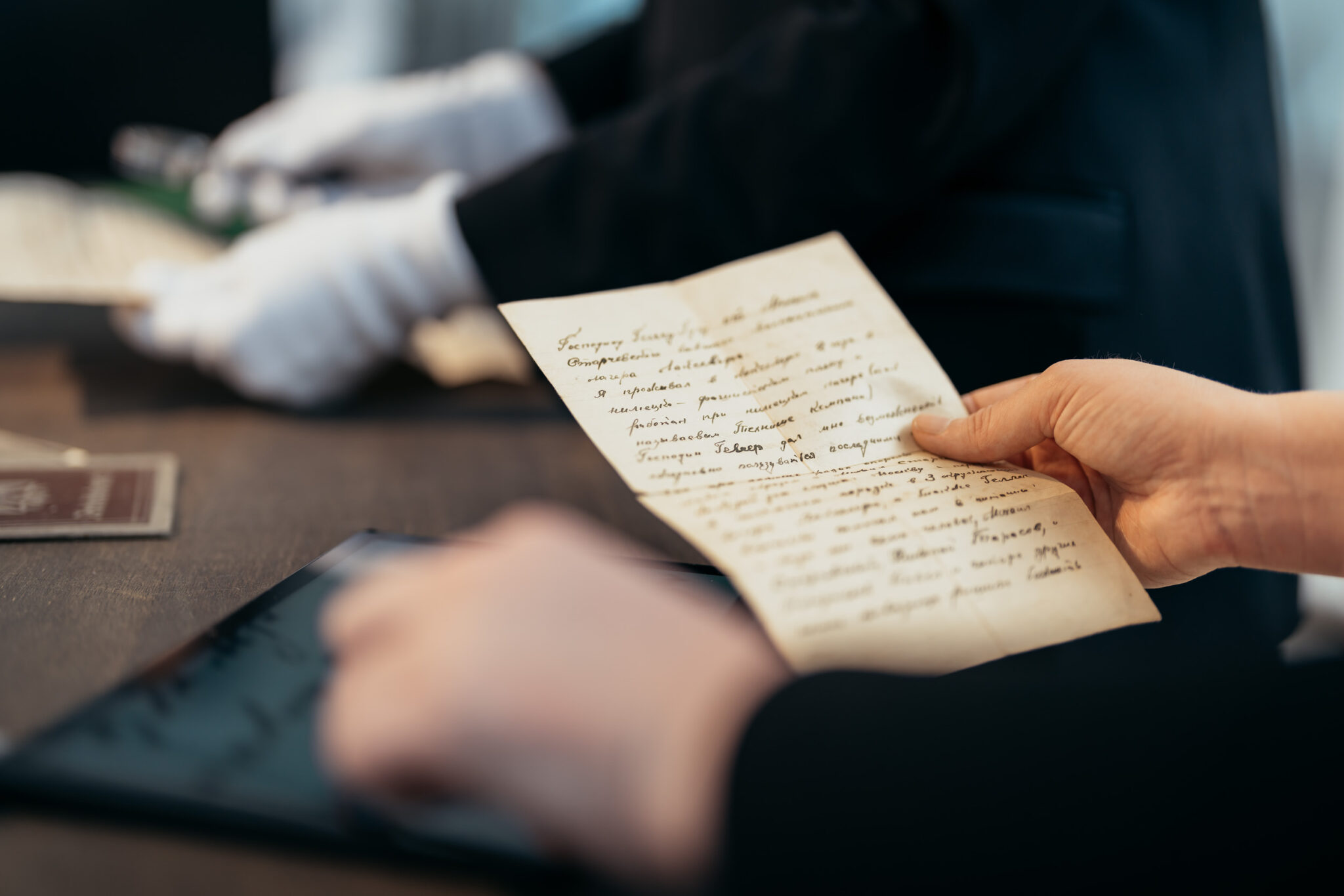 Ein altes handschriftliches Dokument wird in der Hand gehalten